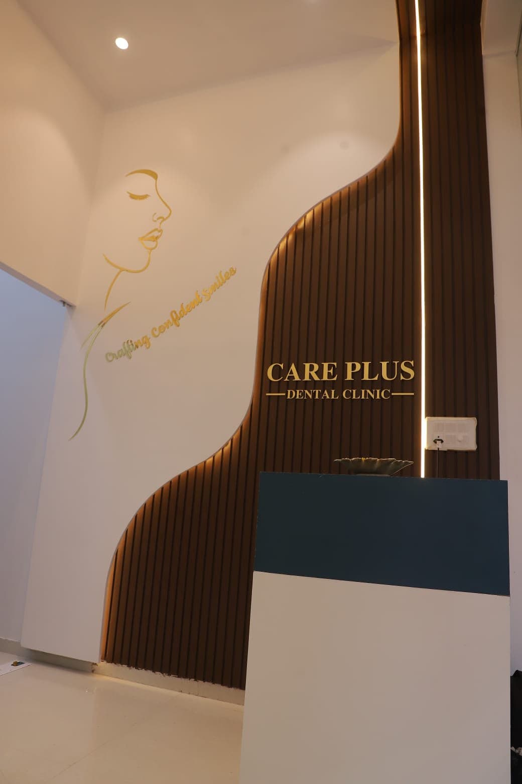 The reception at Care Plus Dental Clinic in Sanpada, Navi Mumbai, with warm light and gold signage