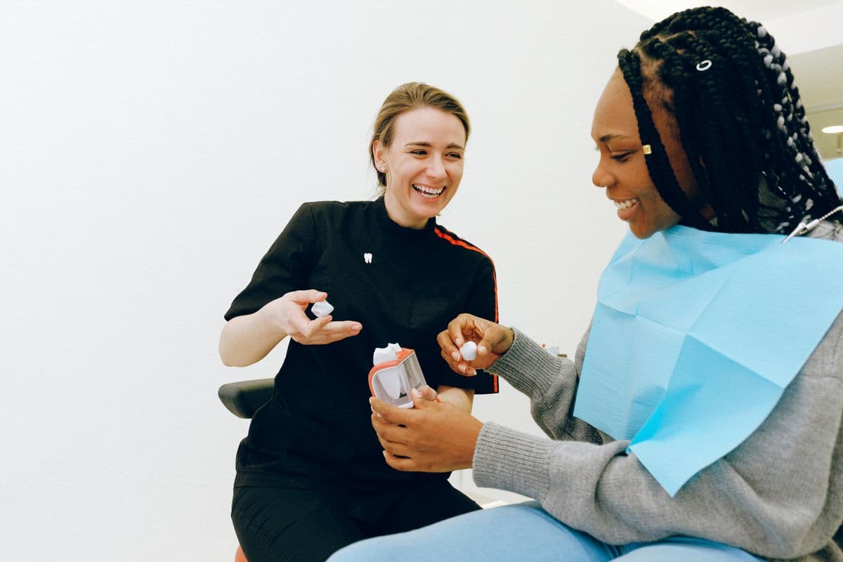 Dentist showing a tooth model during an orthodontic consultation, invisible teeth straightening Sanpada