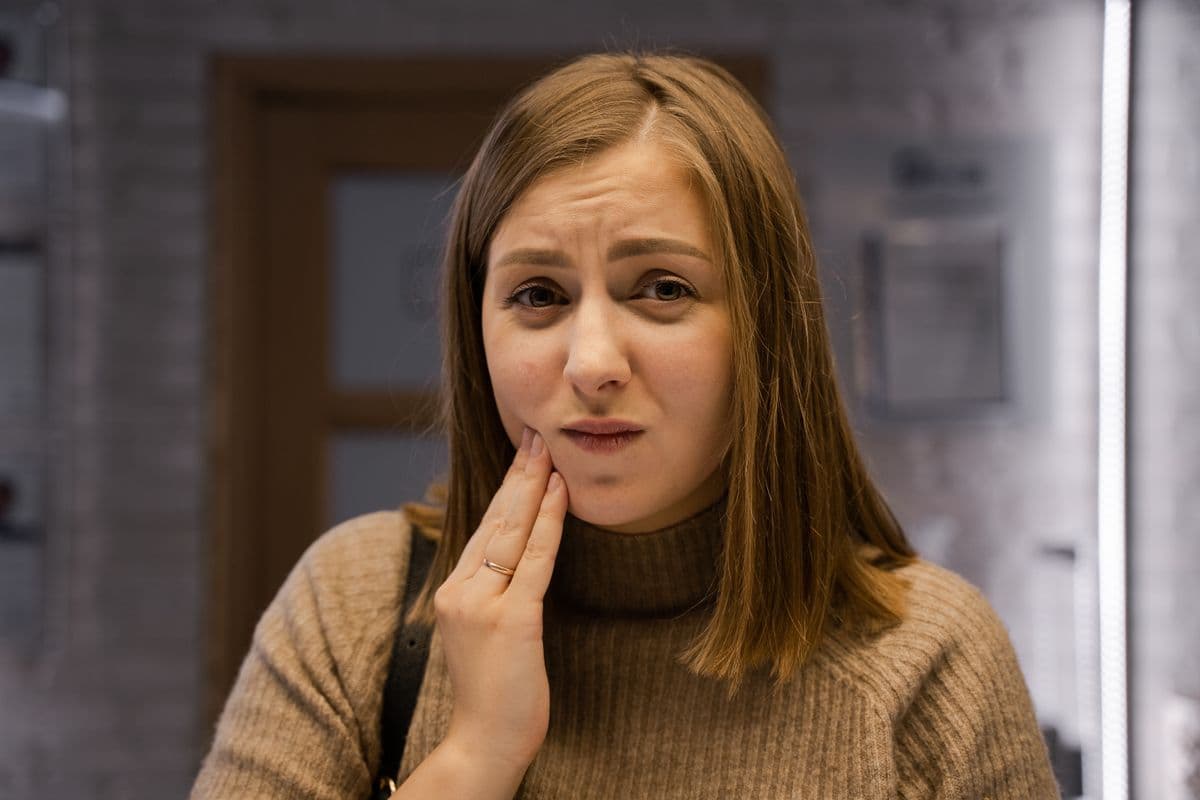 Dental emergency Sanpada, woman holding her jaw with a toothache at night